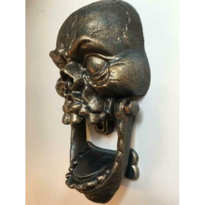 Gietijzeren bronskleurige schedel als deurklopper.